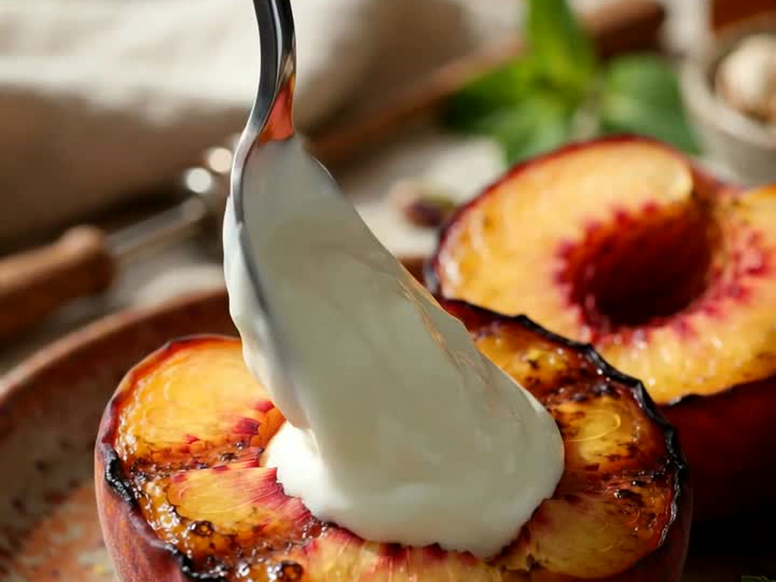 A warm grilled peach half topped with cool Greek yogurt